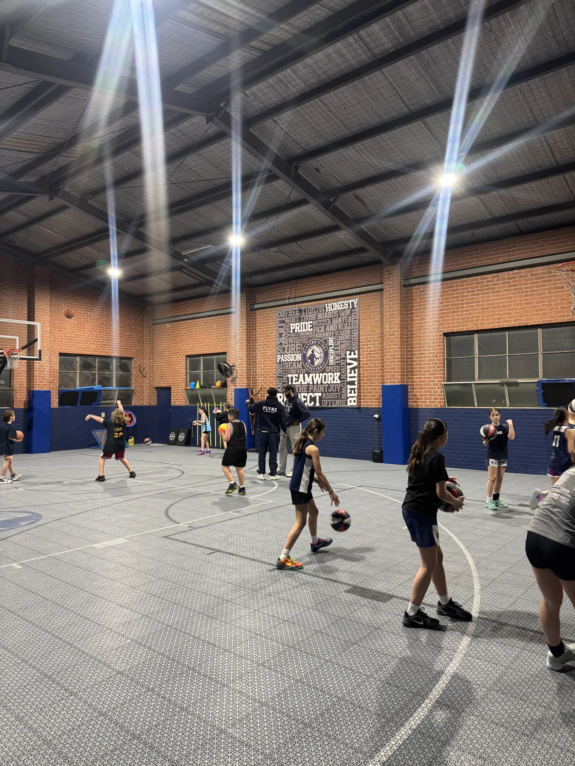 Students playing basketball in a school sports hall