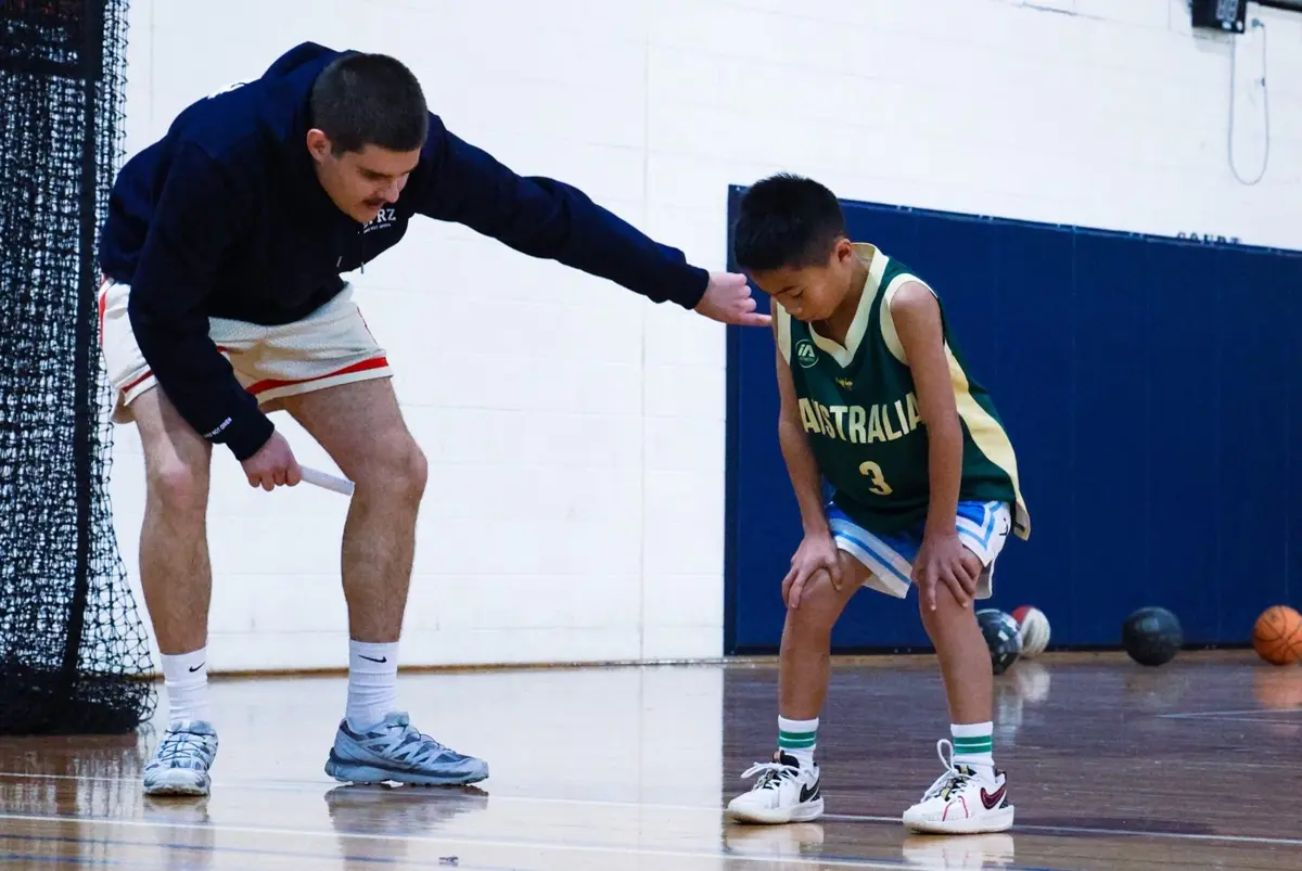 A Players First coach correcting a young player's stance