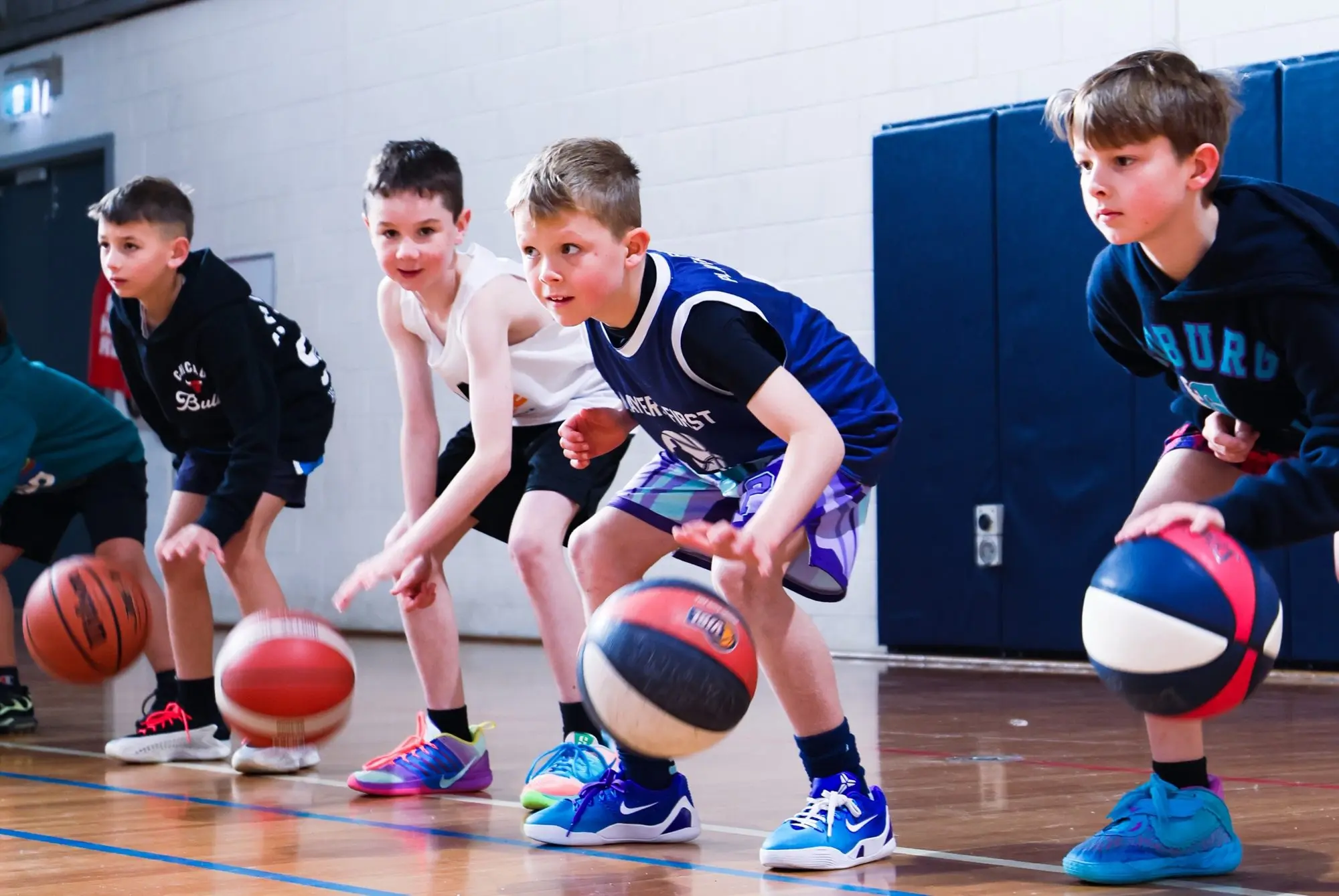 Kids dribbling in a line at a Players First holiday camp