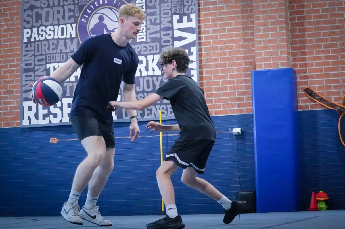 A Players First coach running a one-on-one defensive drill with a young player